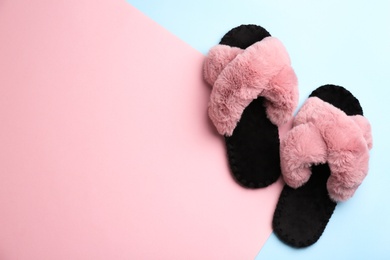 Pair of soft slippers on color background, flat lay. Space for text