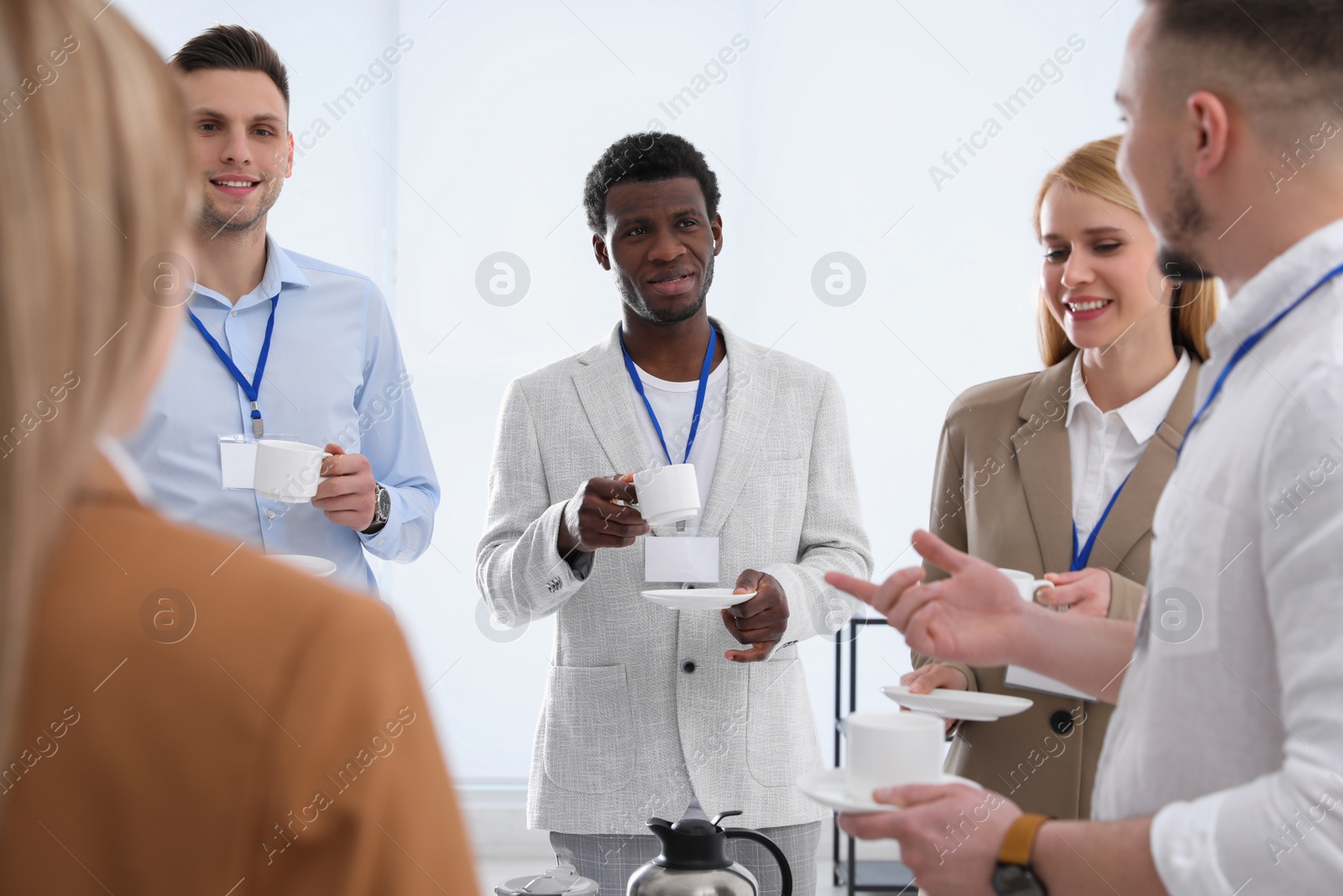 Photo of Group of people chatting during coffee break indoors