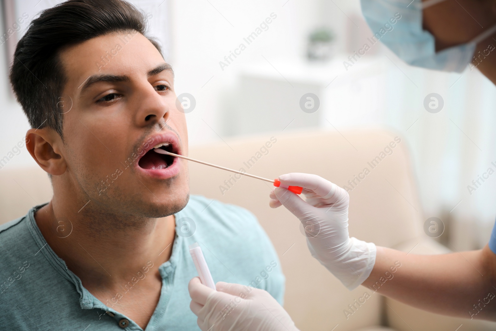 Photo of Doctor taking sample for DNA test from man in clinic