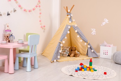Cozy child room interior with play tent, table and modern decor elements