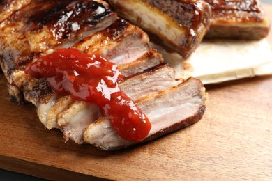 Photo of Delicious grilled ribs with sauce on table, closeup