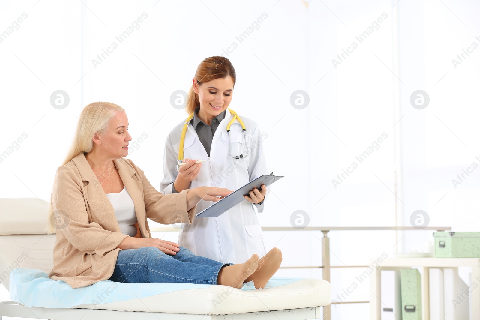 Photo of Doctor working with mature patient in hospital. Space for text