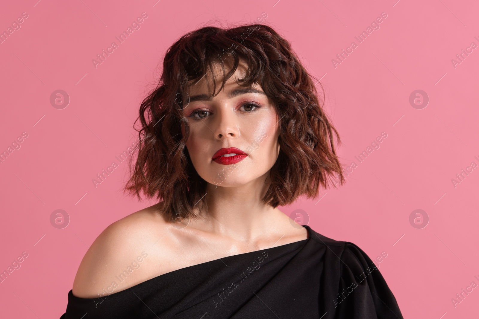 Photo of Portrait of beautiful young woman with wavy hairstyle on pink background