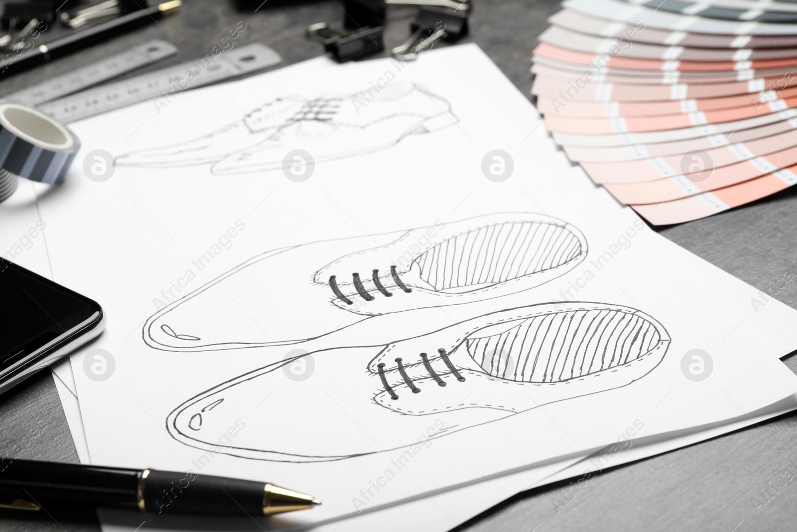 Photo of Drawing of shoes on table, closeup. Designer's workplace