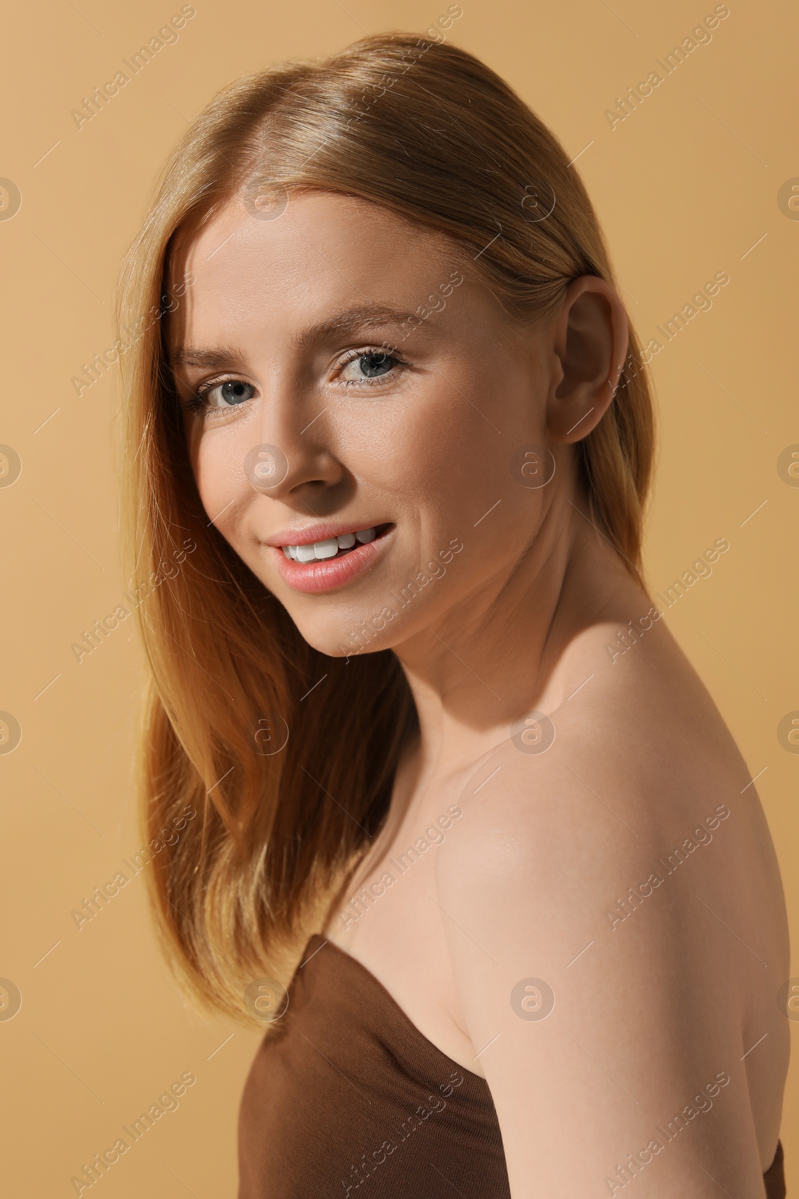 Photo of Beautiful young woman posing on beige background