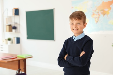 Photo of Little boy in classroom. Stylish school uniform
