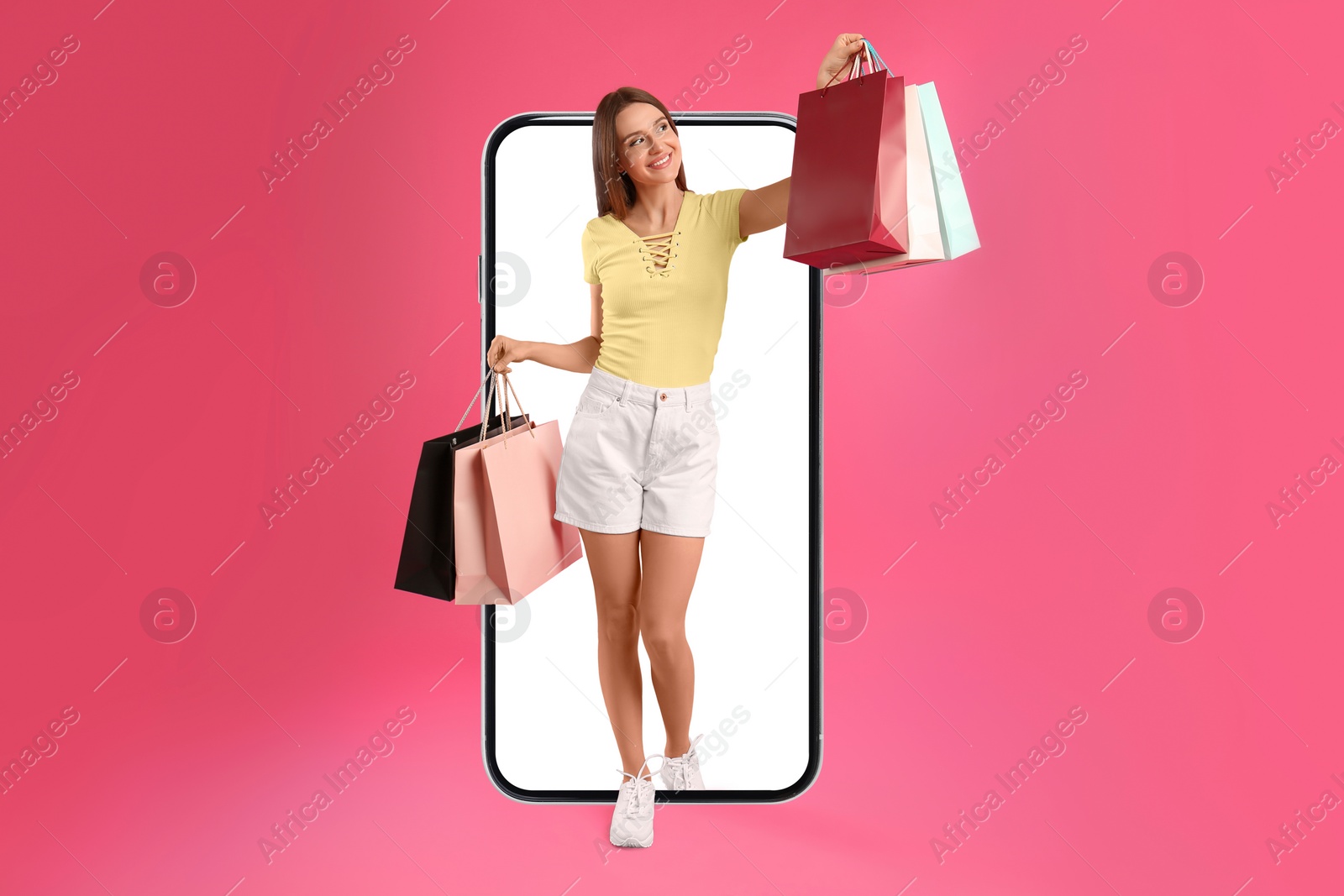 Image of Online shopping. Happy woman with paper bags walking out from smartphone on pink background