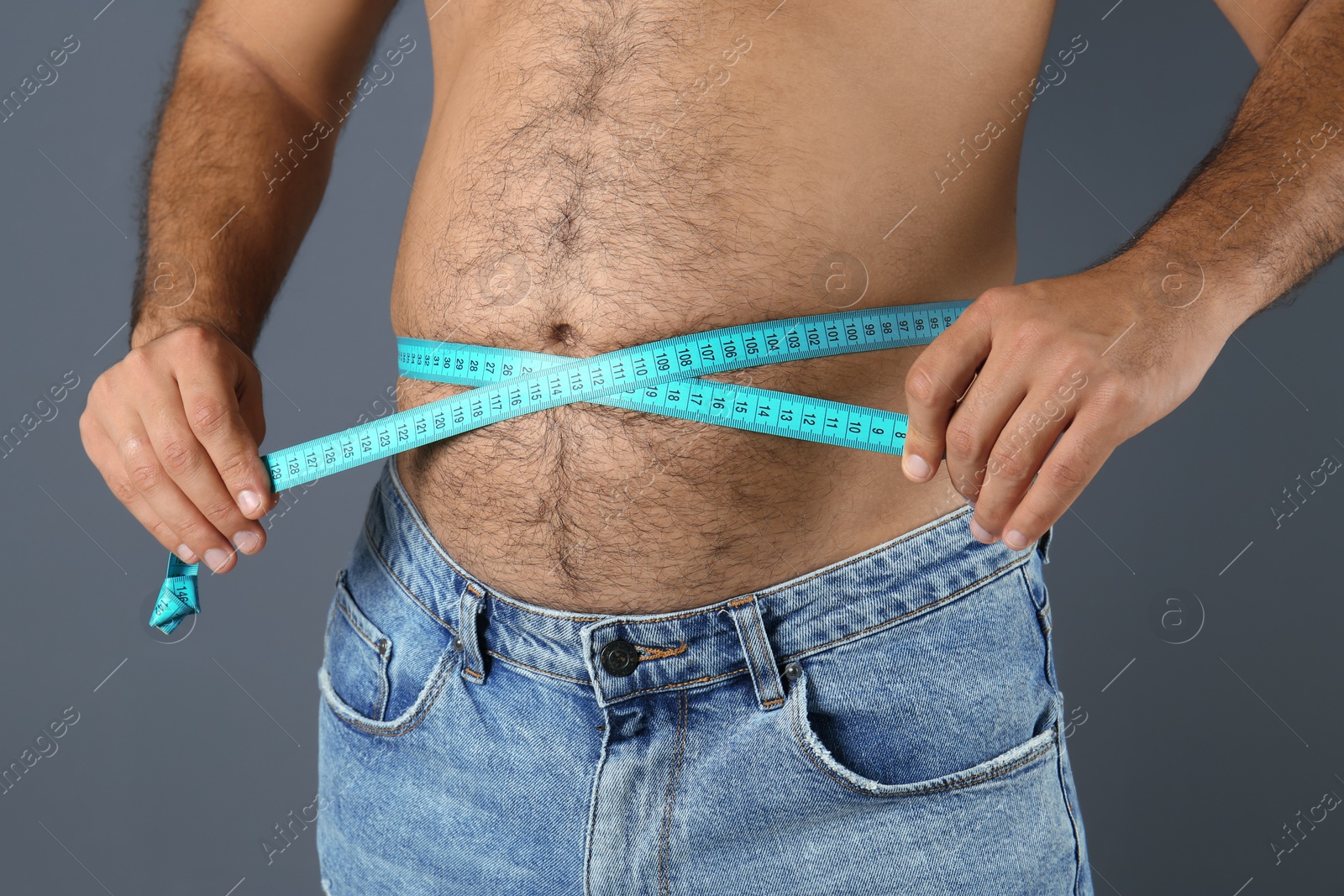 Photo of Overweight man with measuring tape on gray background, closeup