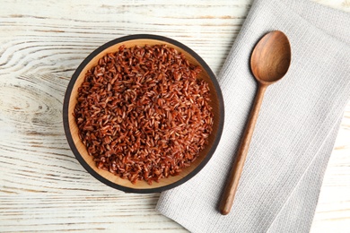 Photo of Flat lay composition with delicious cooked brown rice on white wooden table