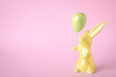 Easter bunny figure on pink background. Space for text