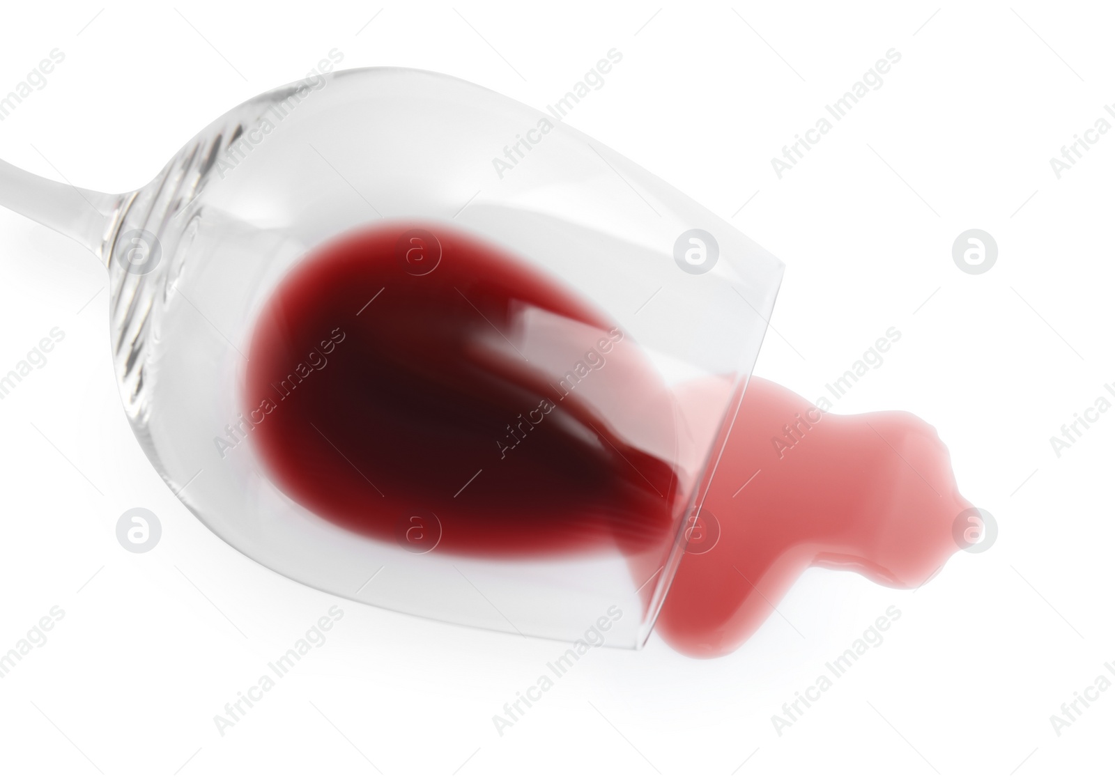 Photo of Transparent glass and spilled exquisite red wine on white background