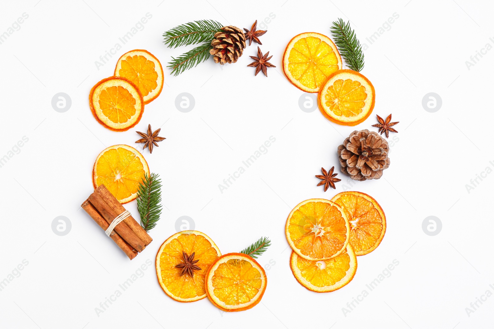 Photo of Frame made of dry orange slices, anise stars, fir branches and cones on white background, flat lay. Space for text