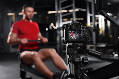 Man recording workout on camera at gym. Online fitness trainer