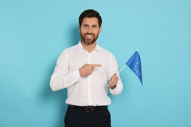 Photo of Man with flag of European Union on light blue background