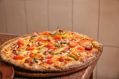 Photo of Wooden board with delicious pizza on table in restaurant. Fresh from oven