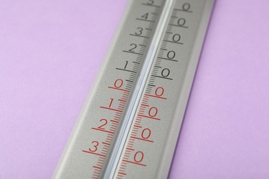 Photo of Modern weather thermometer on lilac background, closeup