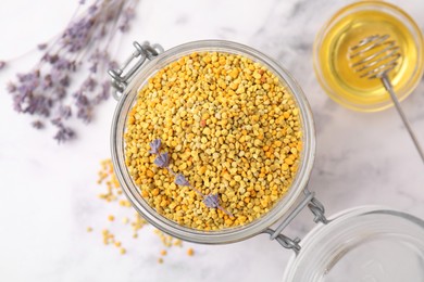 Fresh bee pollen granules, lavender, honey and dipper on light marble table, flat lay