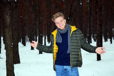 Young man posing in snowy winter forest