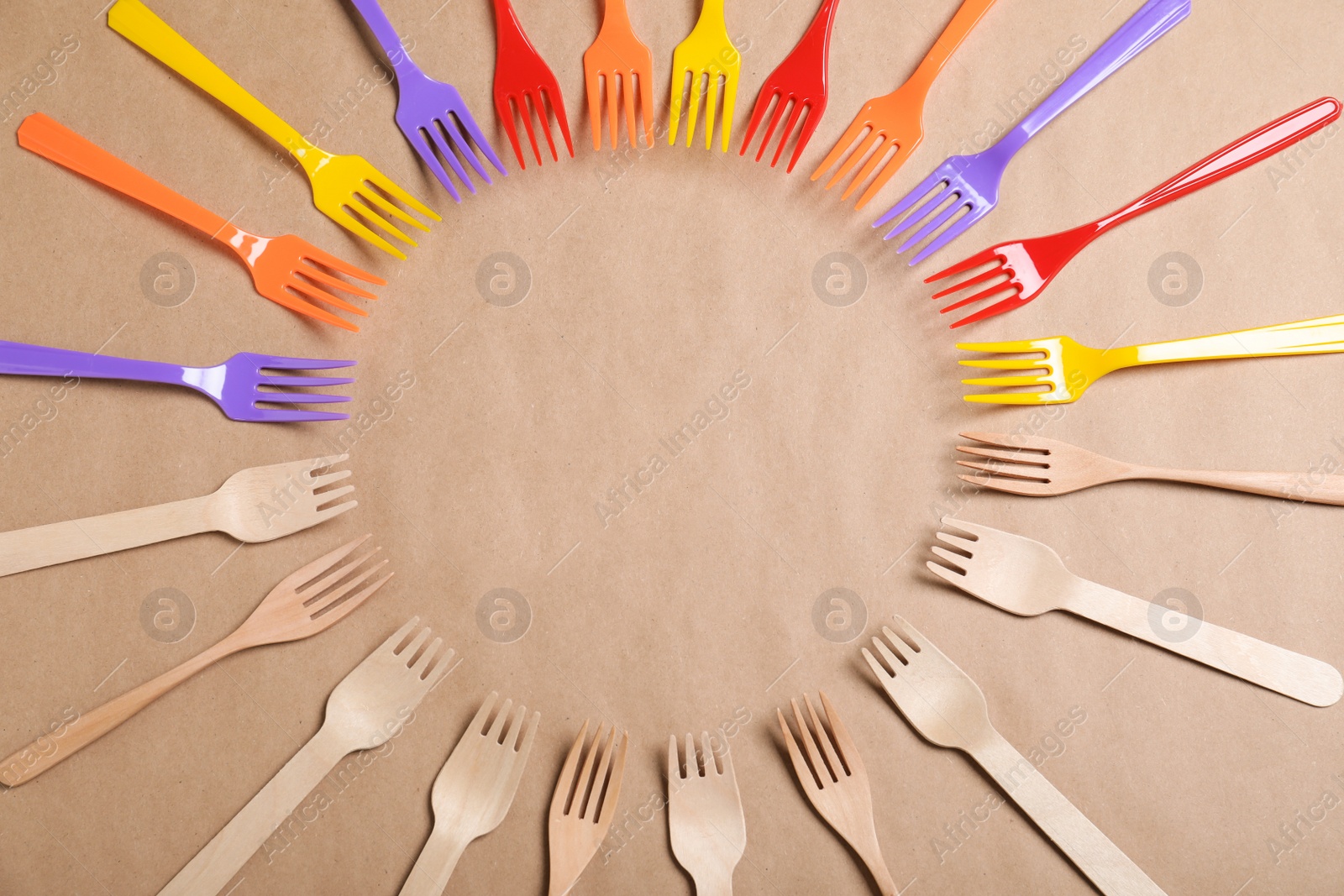Photo of Flat lay composition with plastic and wooden forks on beige background, space for text. Recycling concept