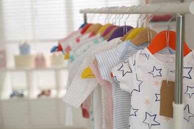 Photo of Baby clothes hanging on rack in store. Shopping concept