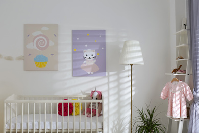 Photo of Baby room interior with cute posters and comfortable crib