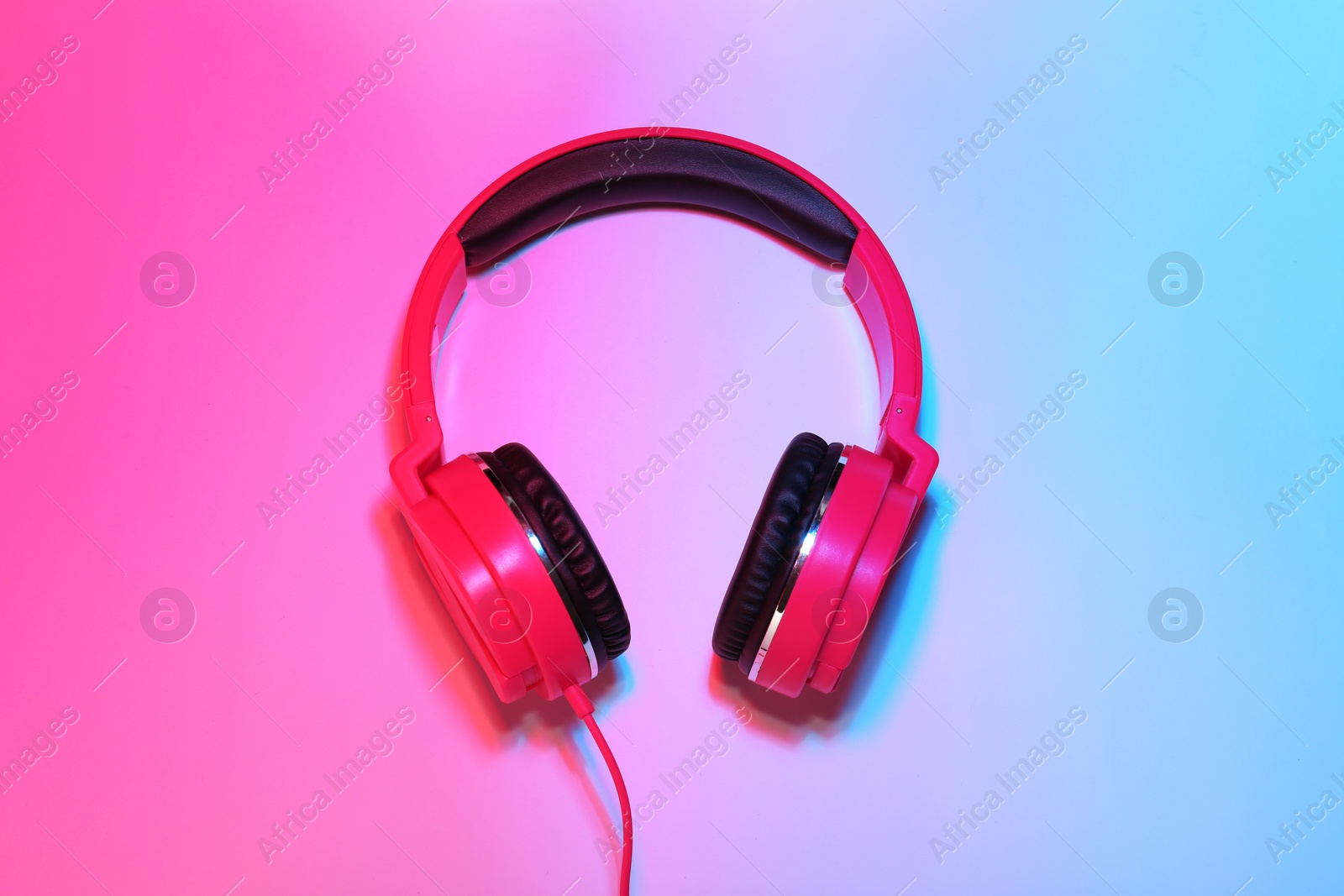 Photo of Stylish headphones on color background, top view