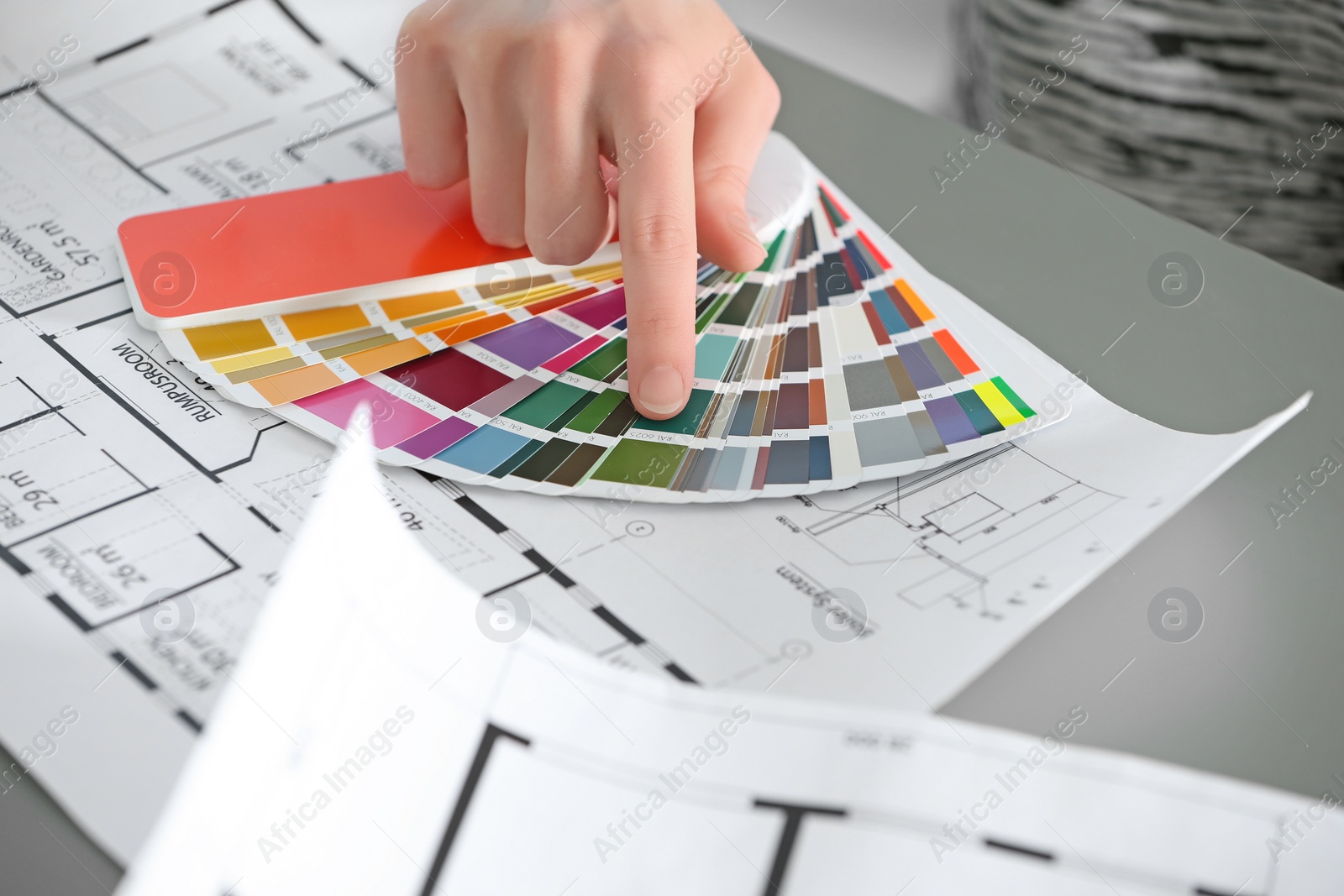 Photo of Female designer working with color palette samples at table