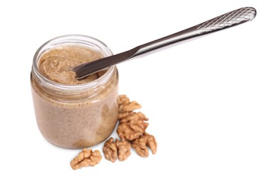 Photo of Tasty nut paste in jar, knife and walnuts isolated on white