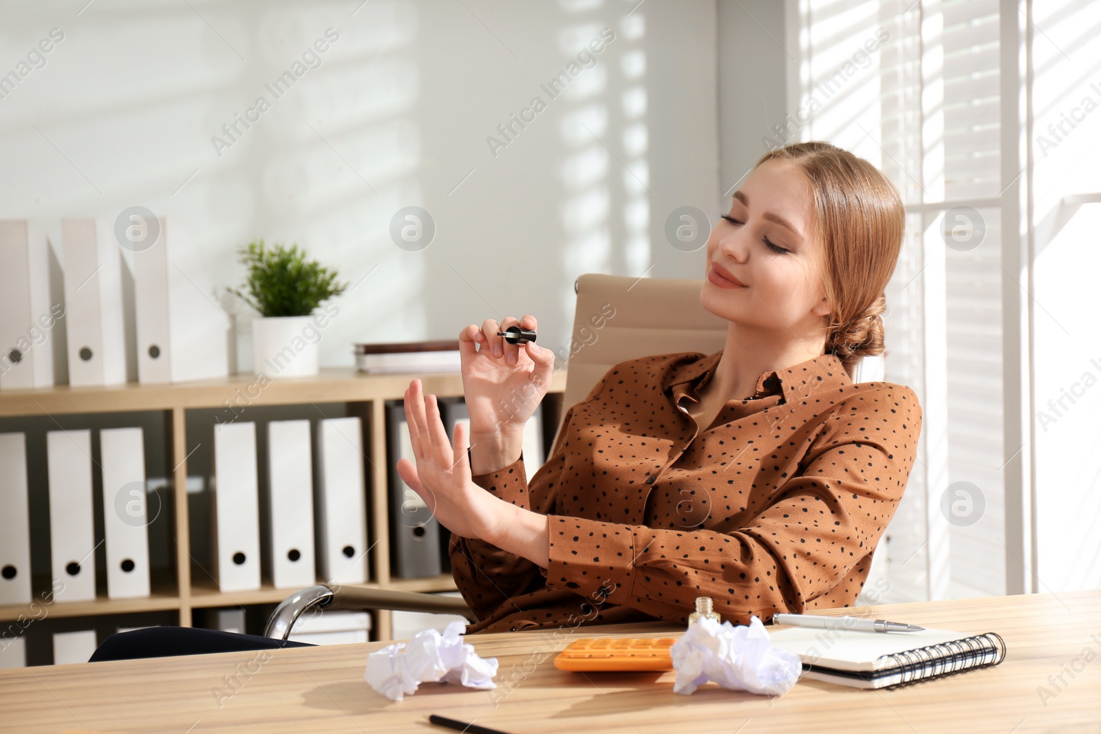 Photo of Lazy office worker doing manicure at desk indoors