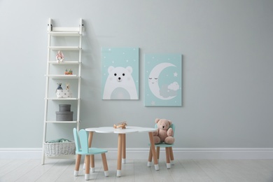 Children's room interior with table and cute pictures on wall