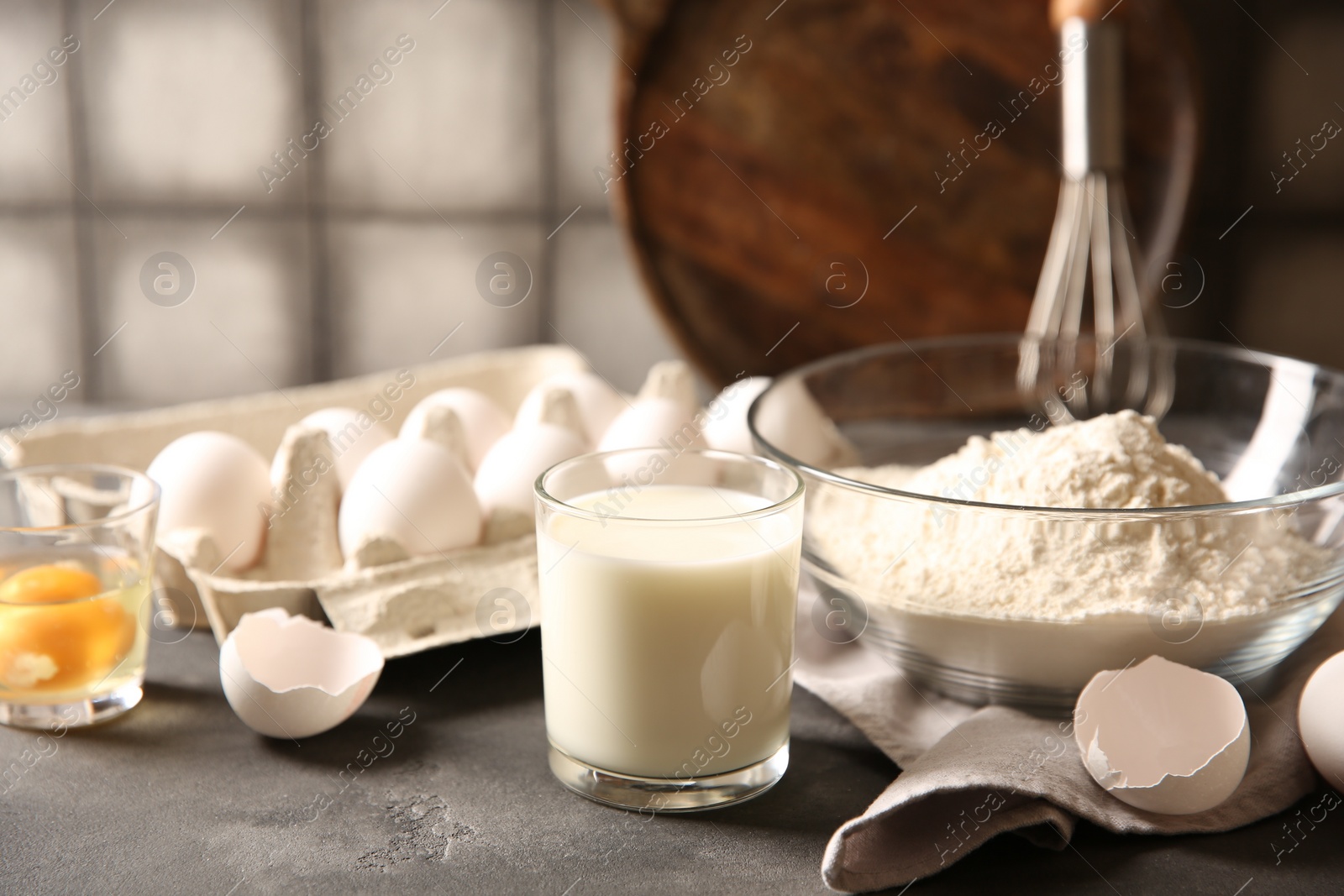 Photo of Different ingredients for dough on grey table, closeup