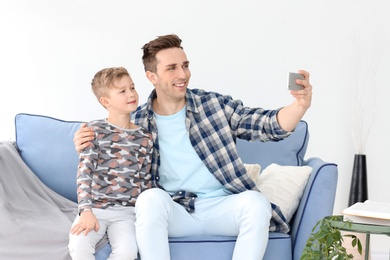 Photo of Dad and his son taking selfie at home
