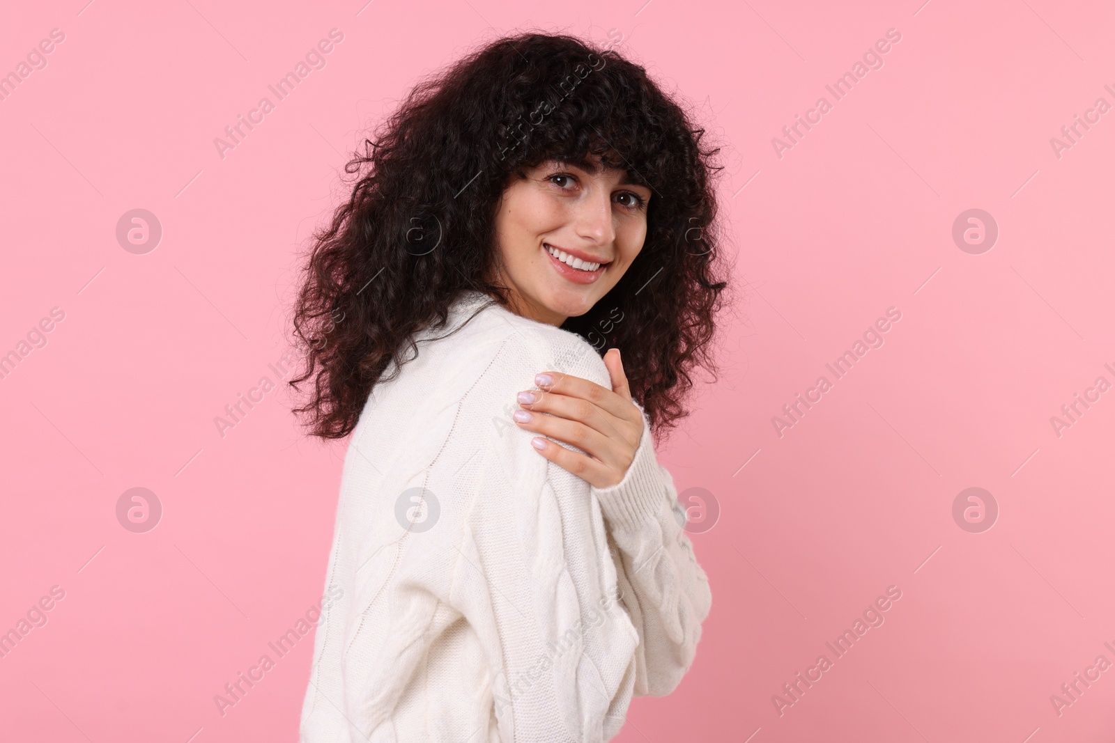 Photo of Happy young woman in stylish white sweater on pink background