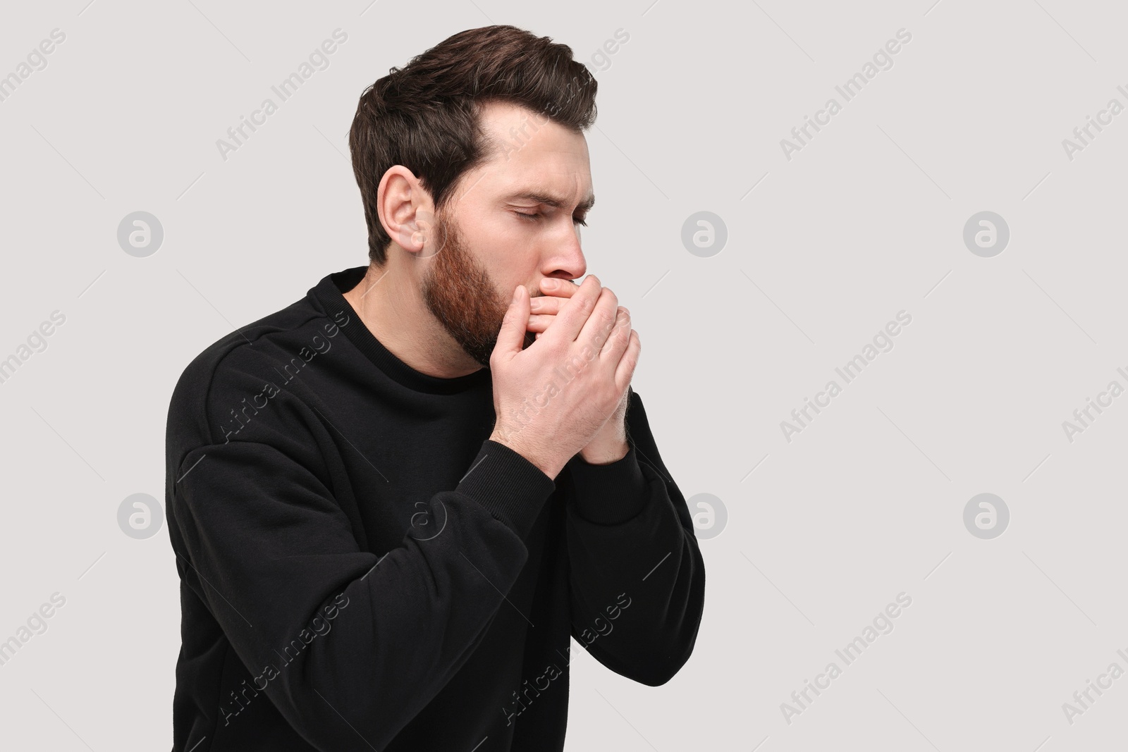 Photo of Sick man coughing on light grey background, space for text. Cold symptoms