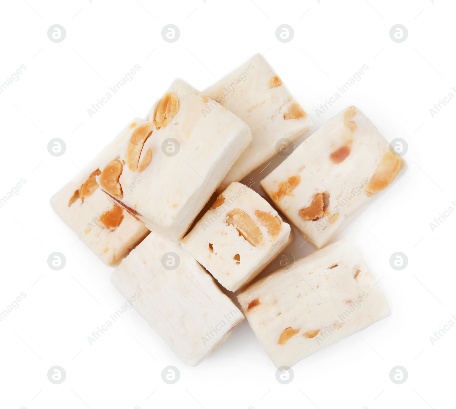 Photo of Many pieces of delicious nougat on white background, top view