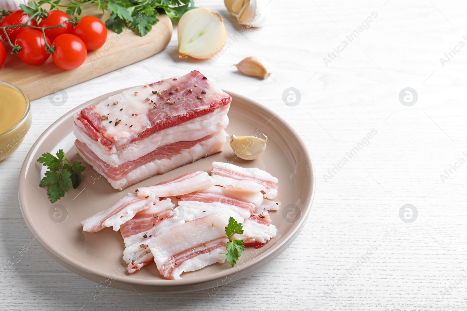 Photo of Tasty salt pork with parsley on white wooden table, space for text