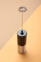 Photo of Milk frother wand on color background, above view