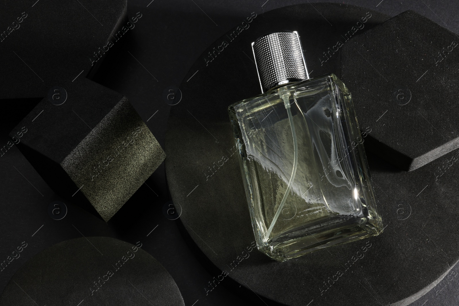 Photo of Stylish presentation of luxury men`s perfume in bottle on black background, top view. Space for text