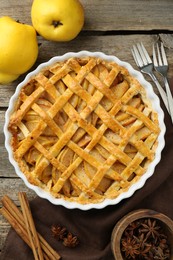 Tasty homemade quince pie served on wooden table, flat lay