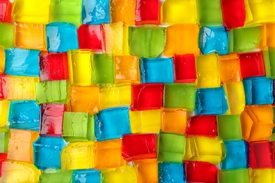 Photo of Tasty colorful jelly cubes as background, top view