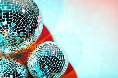 Photo of Bright shiny disco balls on color background, above view. Space for text