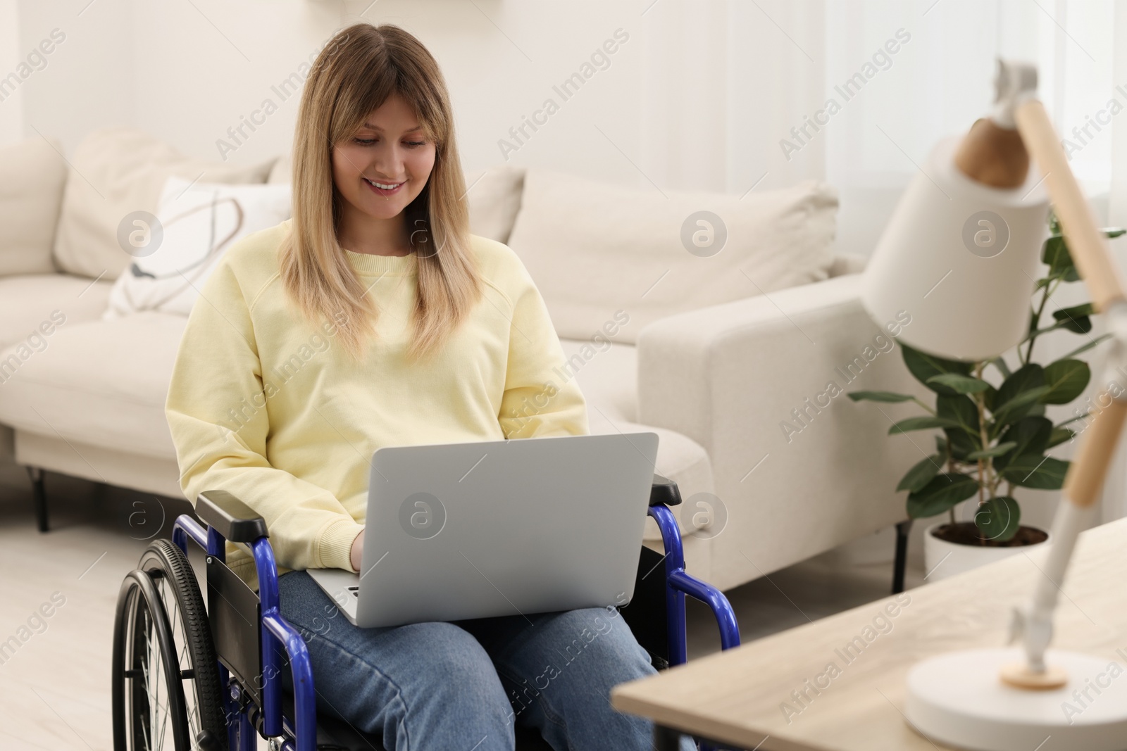 Photo of Woman in wheelchair using laptop at home