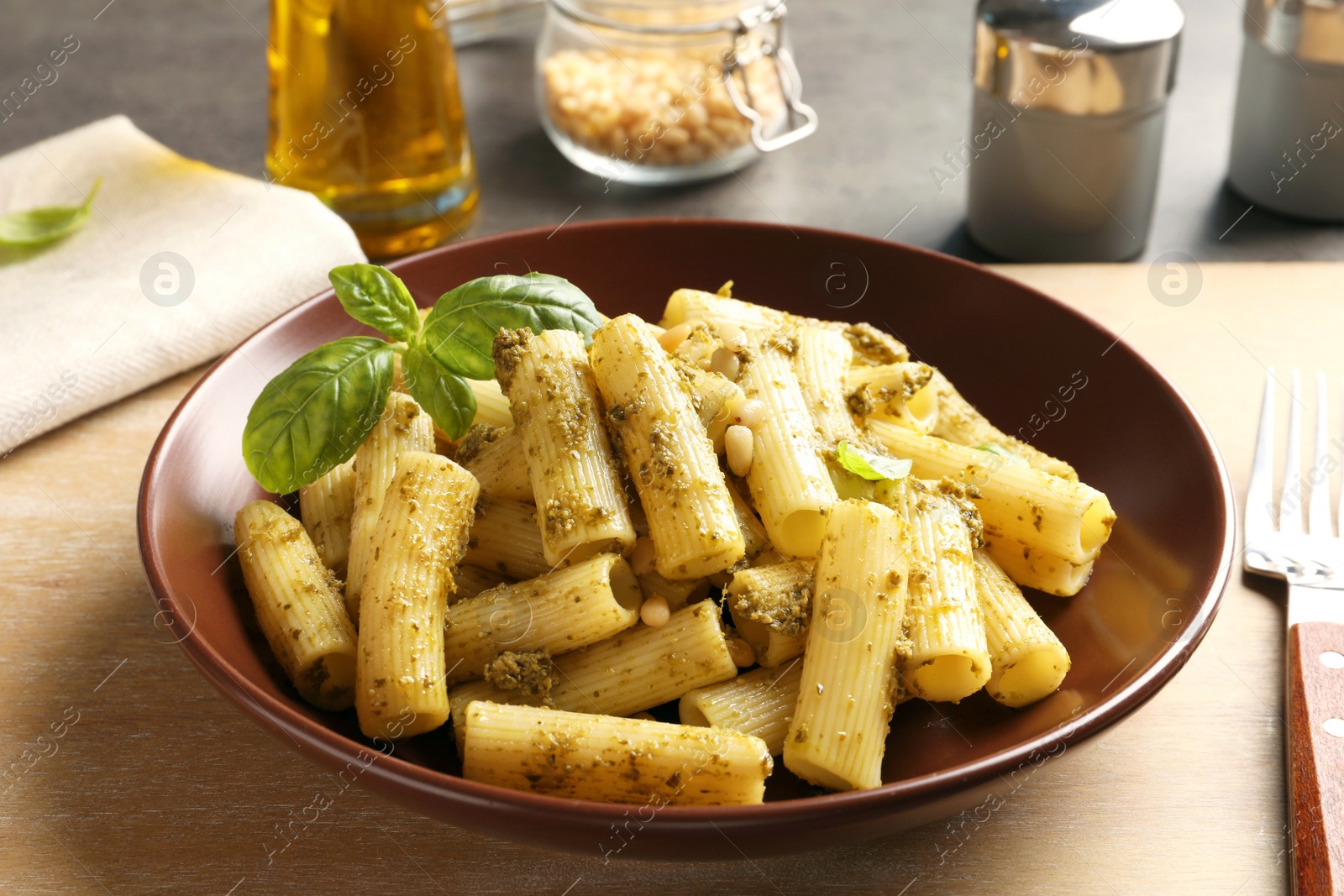 Photo of Plate of delicious basil pesto pasta served for dinner on table