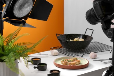 Photo of Professional equipment and composition with delicious meat medallion on white table in studio. Food photography