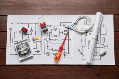 Photo of Wiring diagrams, screwdriver and different electrician's equipment on wooden table, flat lay