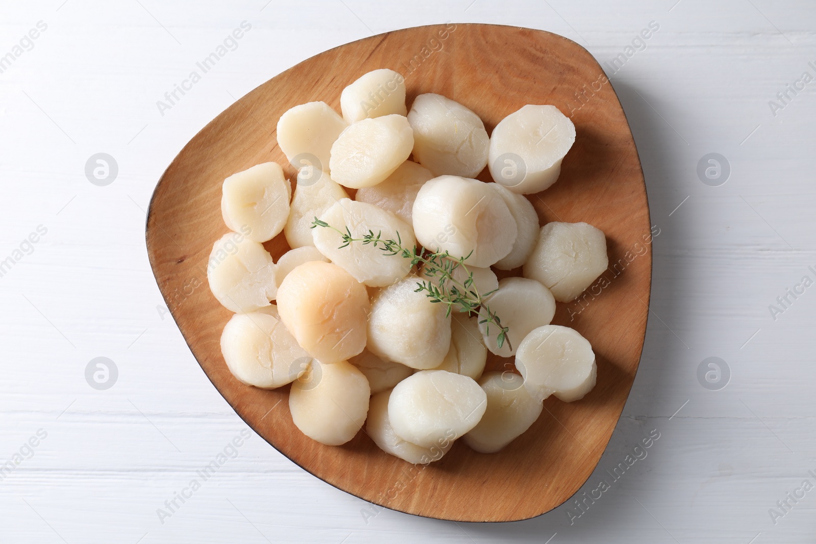 Photo of Fresh raw scallops and thyme on white wooden table, top view