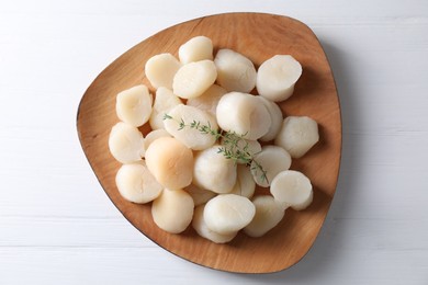 Fresh raw scallops and thyme on white wooden table, top view