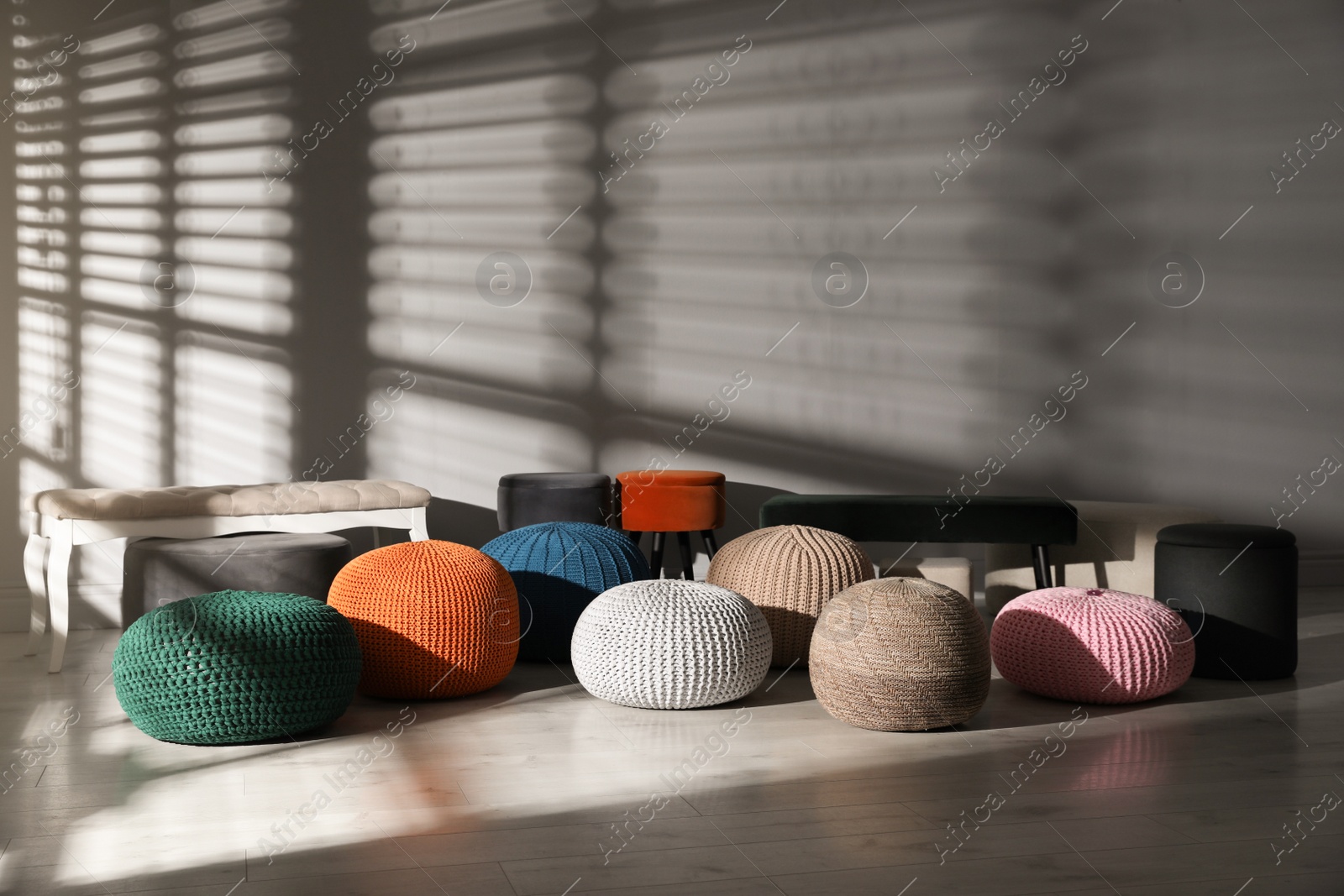 Photo of Many stylish different poufs and benches in room. Home design