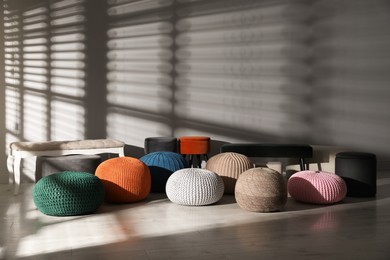 Many stylish different poufs and benches in room. Home design