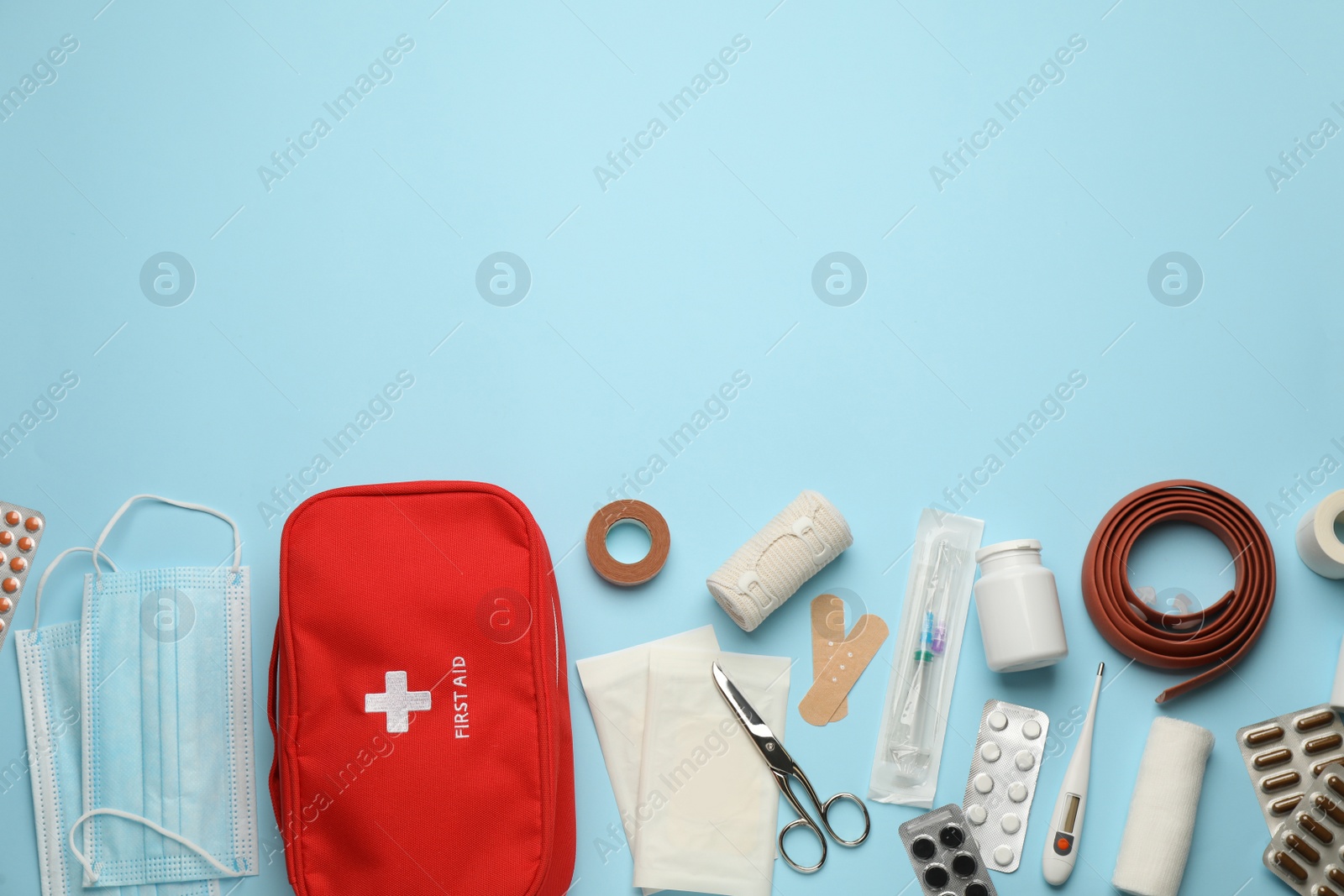 Photo of Flat lay composition with first aid kit on light blue background, space for text